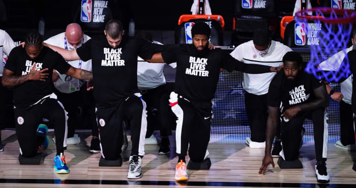 Los Angeles Clippers players kneel in honor of the Black Lives Matter movement during the playing of the national anthem prior to an NBA basketball game